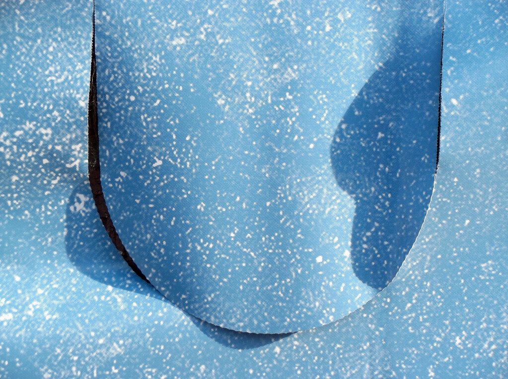 A blue shape on blue. The eye stops before a word turns up.
