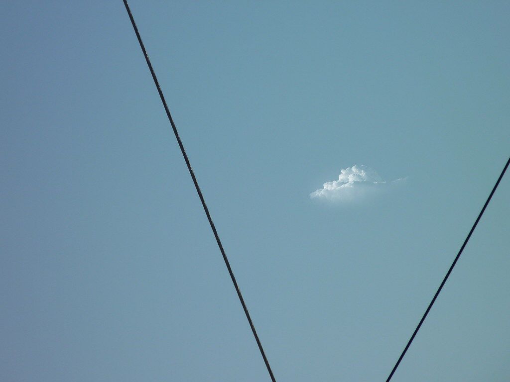 2 wires and a small cloud in open sky.