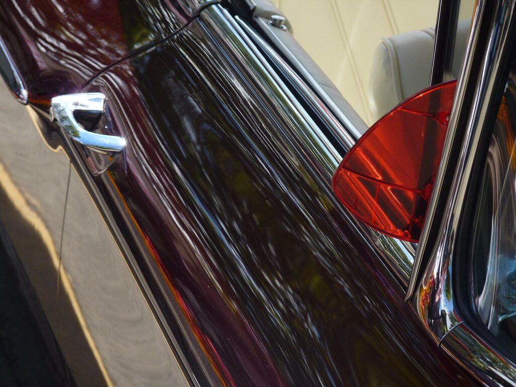 A red tail light in a dark car door.