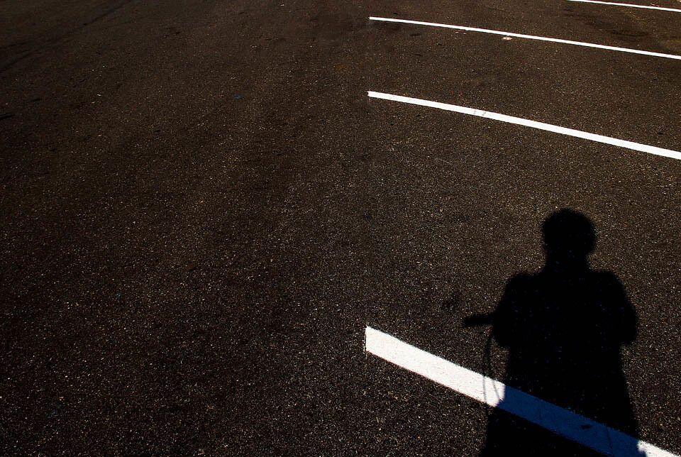 A photographer’s shadow on the asphalt.