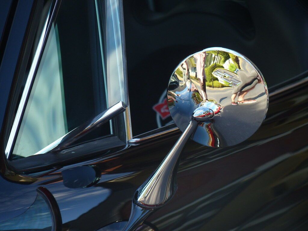 A wing mirror reflecting the street.